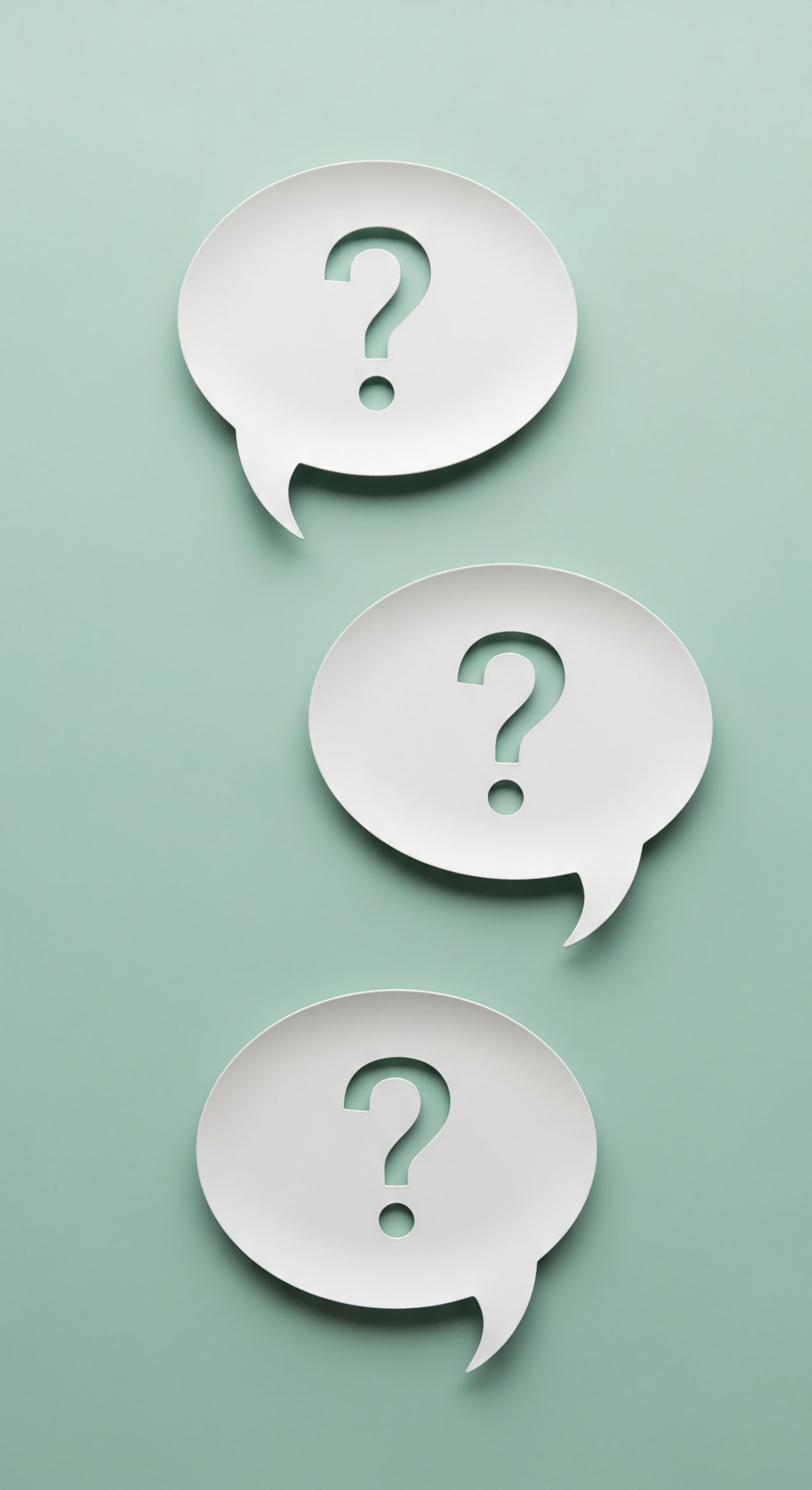 Tres bafarades de text blanques amb signes d'interrogació retallats, sobre un fons verd menta.